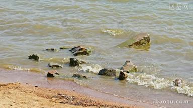 浪打在岸边的石头沙滩上